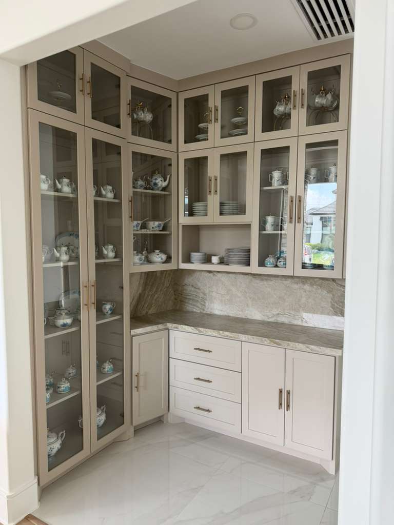 Custom glass-front kitchen display cabinets with brass hardware