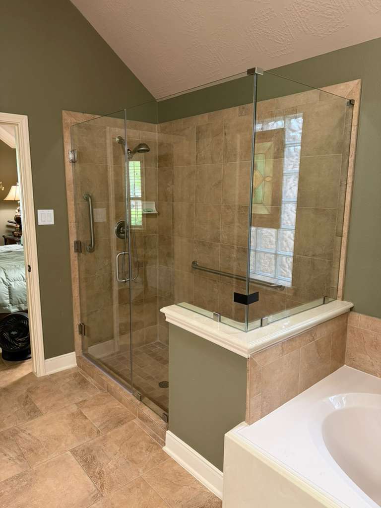 Neo-angle frameless shower next to soaking tub with brushed nickel hardware