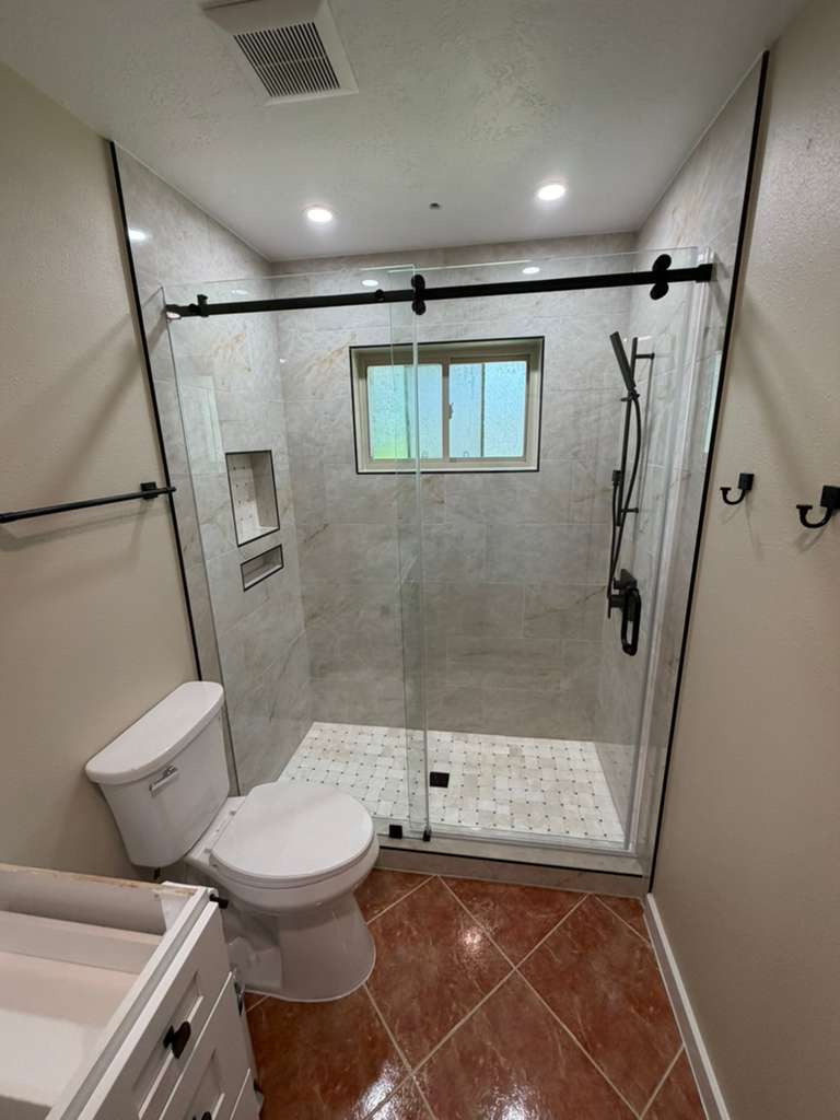 Sliding barn-door shower enclosure with matte black hardware