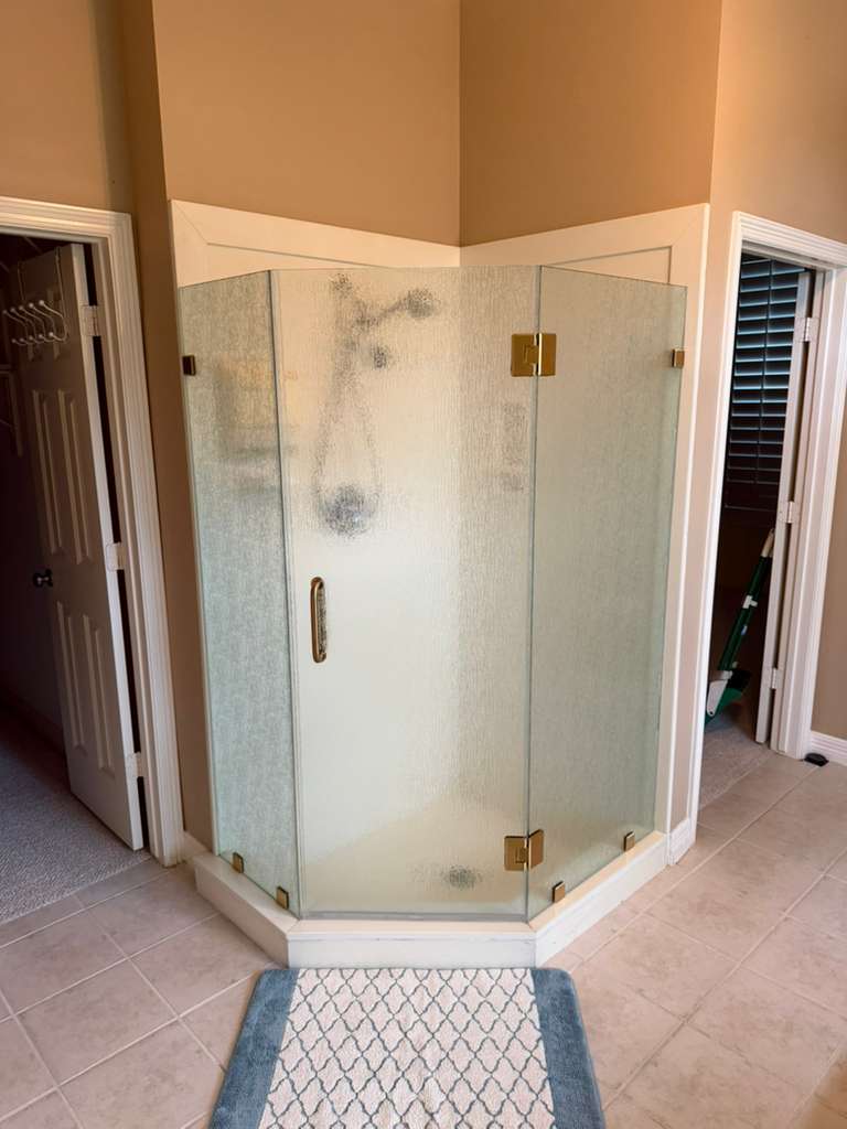 Neo-angle frameless shower with rain glass and gold hinges