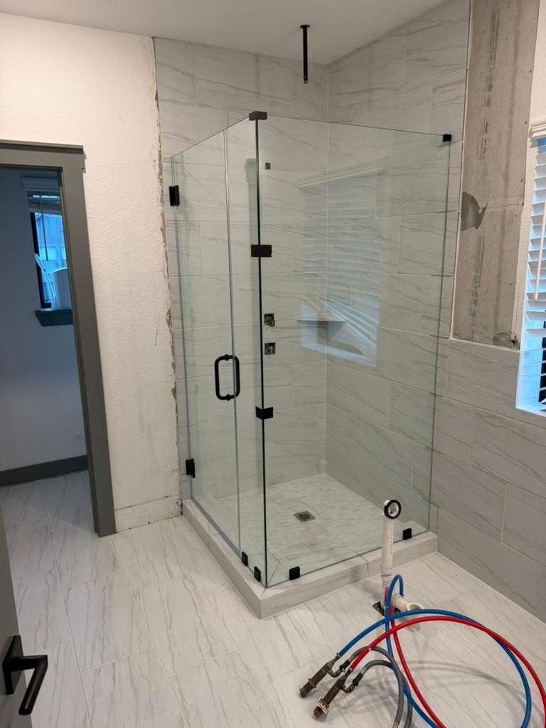 Corner frameless glass shower enclosure with matte black clips